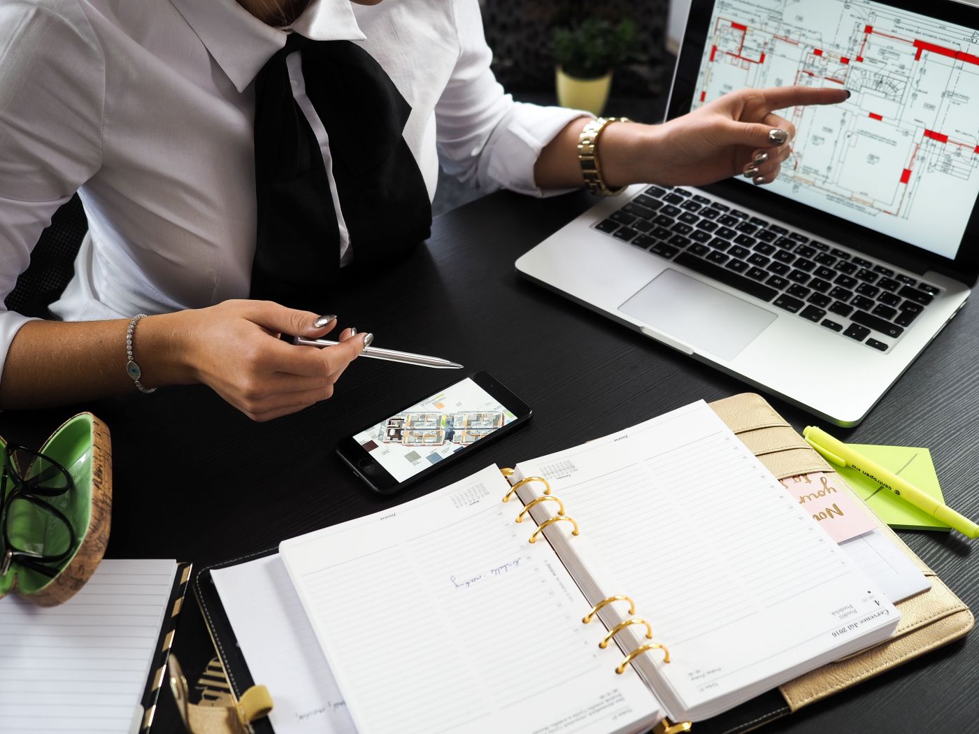 Une conseillère AB Home analyse le plan d'un bien sur ordinateur